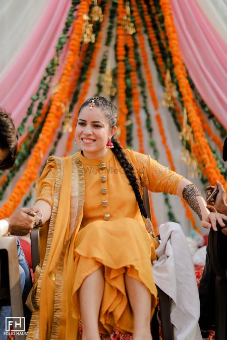 Bride wearing a simple yellow suit for mehendi