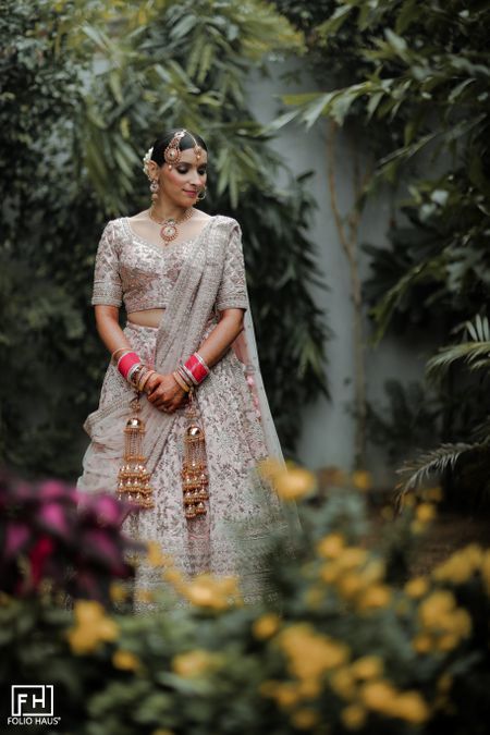 Bride wearing pastel pink bridal lehenga.