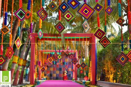 Colourful mehendi entrance decor with hanging patterns