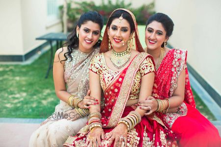 Photo of Bride in red and gold lehenga with bridesmaids