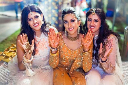 Photo of Bride in mustard anarkali with bridesmaids on mehendi