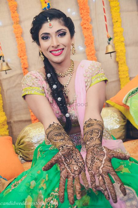 Bride in floral lehenga showing off mehendi hands