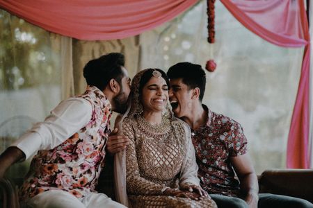 Photo of Candid shot of a bride with her brothers.