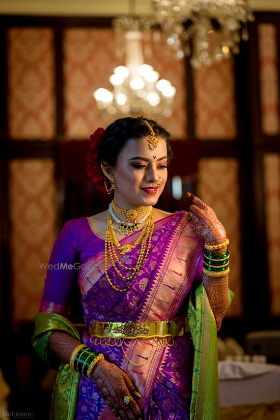 Photo of A Marathi bride in a purple saree with gold jewellery