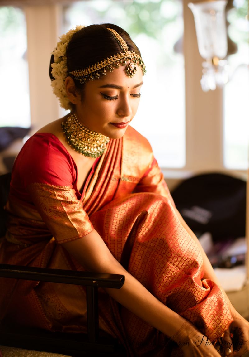 Photo of South Indian bride getting ready portrait in orange saree