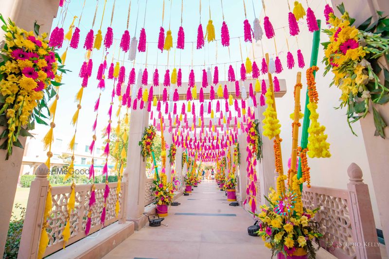 Photo of mehendi entrance decor idea with tassels and florals