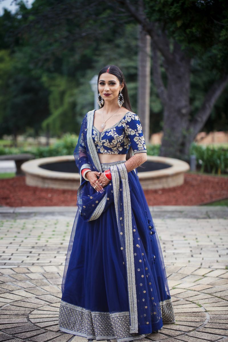 Photo of Bride in dark blue designer lehenga.