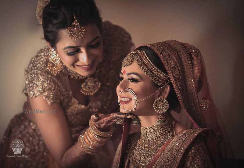 Photo of Bride Posing with Sister While Getting Ready