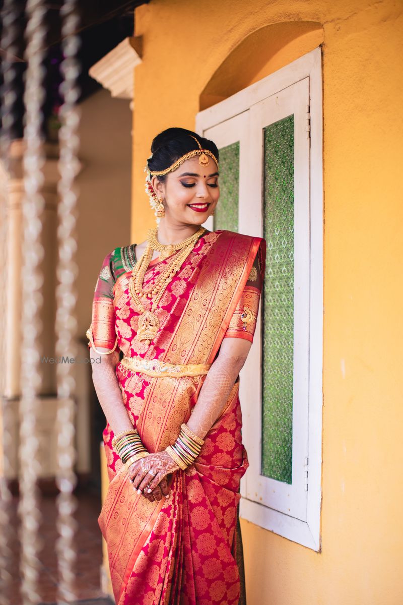 Photo of A south Indian bride wearing a kanjeevaram saree and gold, temple  jewelry