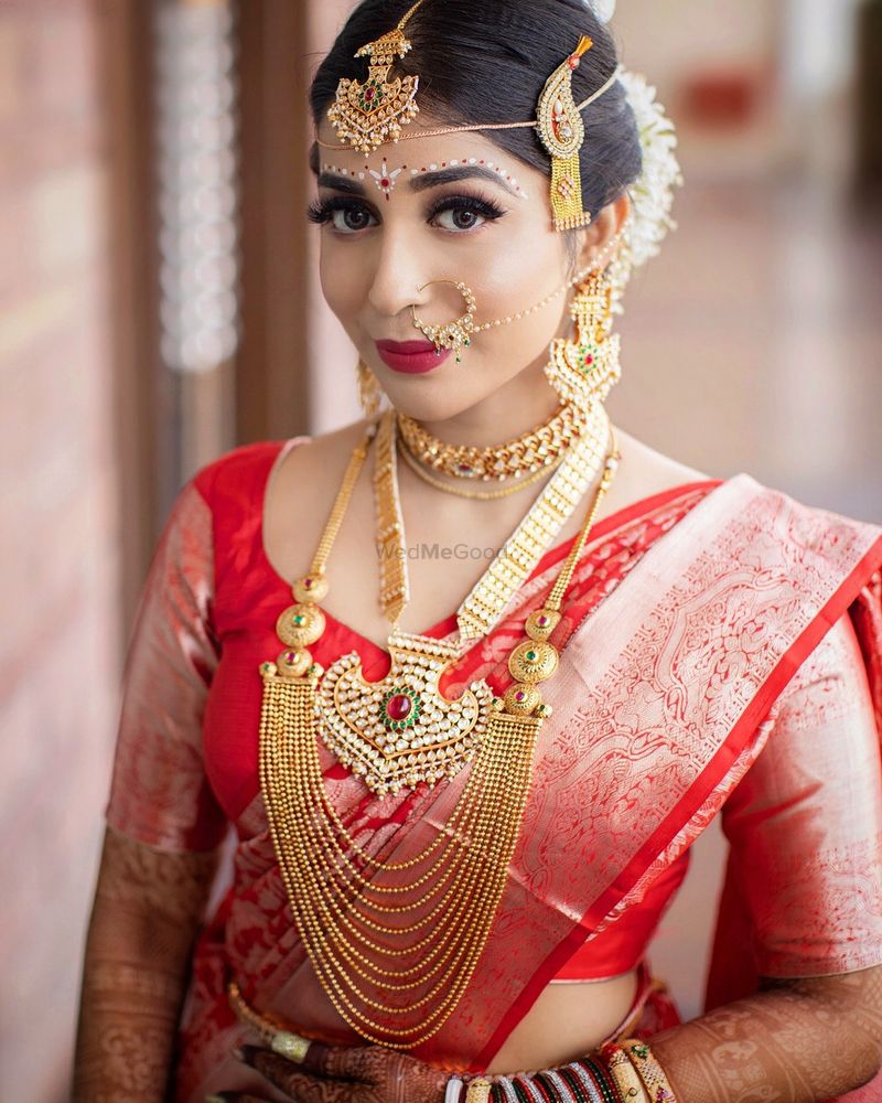 Photo of Bengali bride in her red saree and bridal jewellery.