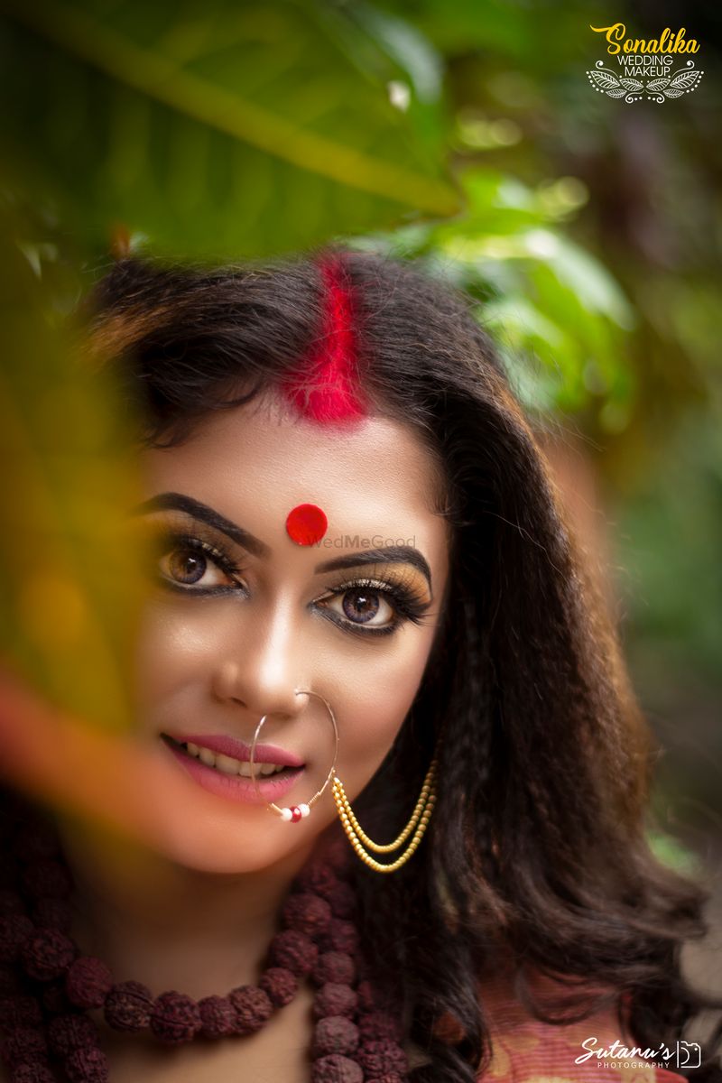 Portrait of beautiful Indian girl in heritage stepwell wearing traditional  Indian red saree, gold jewellery and bangles. Maa Durga agomoni shoot  concept. Traditional woman on stairs with poses photo – One person