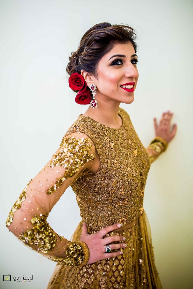 Photo of Blingy gold anarkali with red roses in a bridal hairstyle
