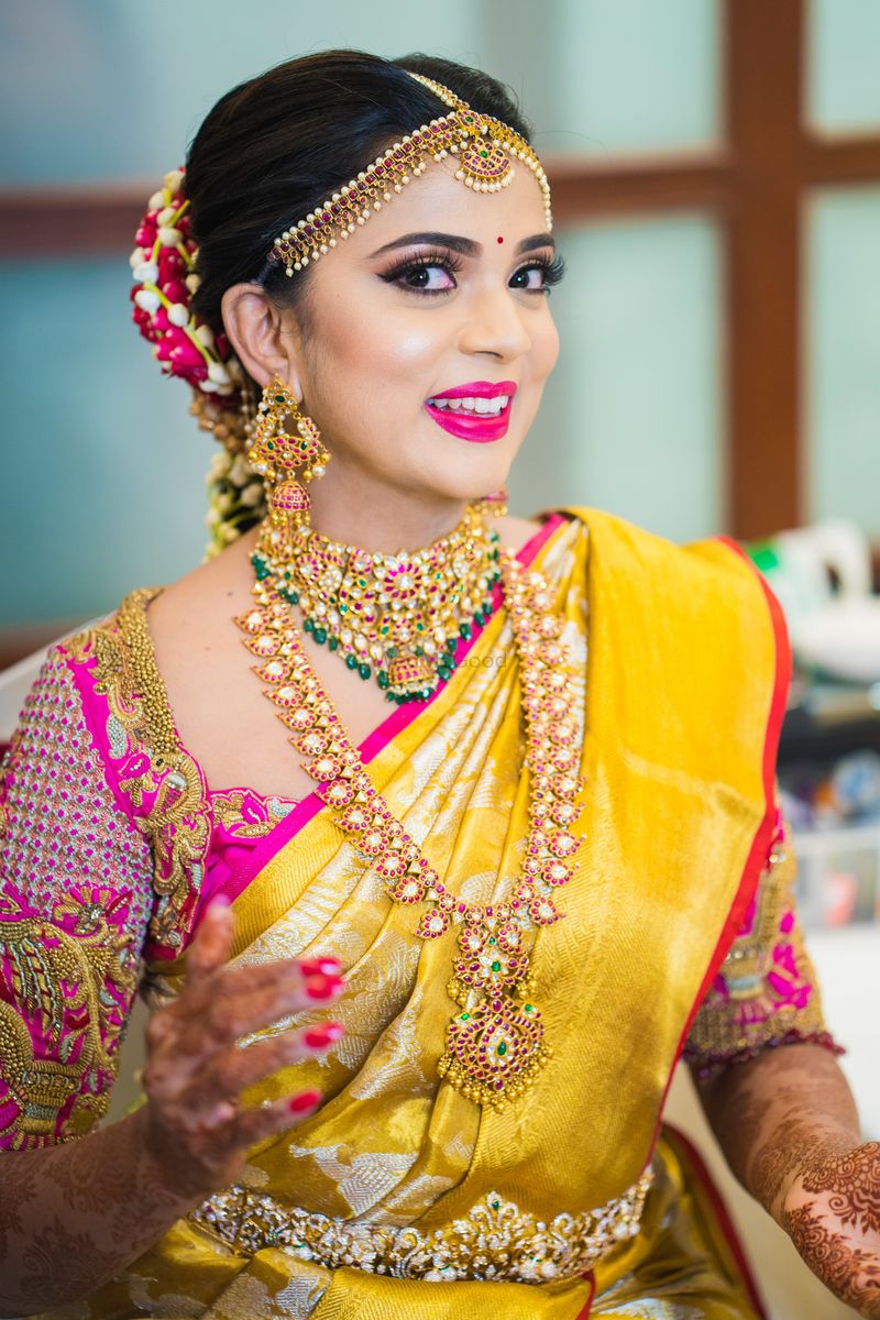 Photo of South Indian bridal look with bright pink lips and yellow saree