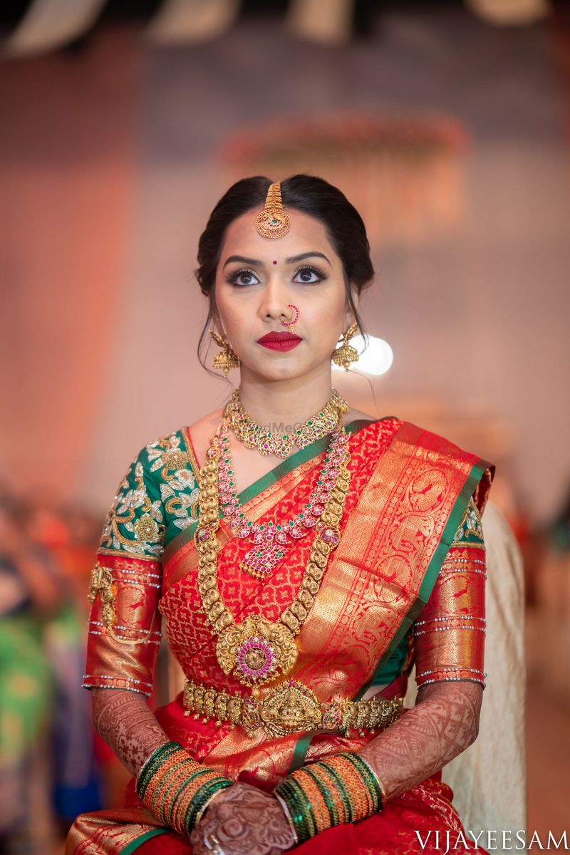 Photo of South indian bride wearing a dark green and purple kanjivaram saree  on her wedding