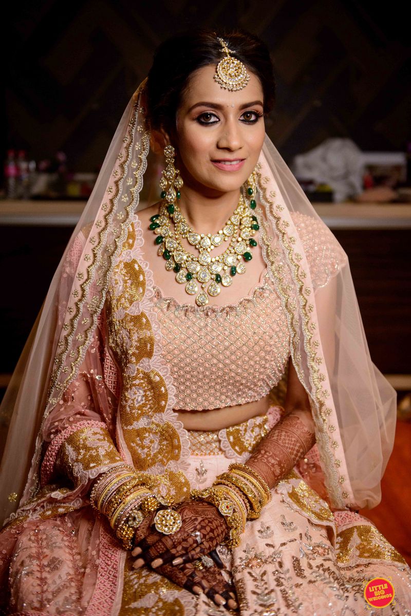 Photo of simple pastel bridal lehenga with contrasting jewellery