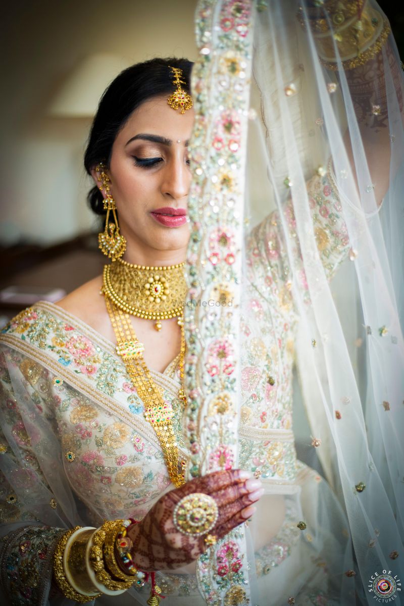 Photo of Bride wearing embellished golden lehenga with contrasting jewellery .